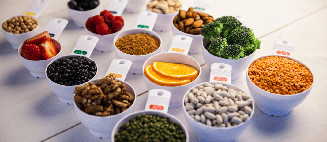 A variety of fruit, nuts and vegetables in measuring cups